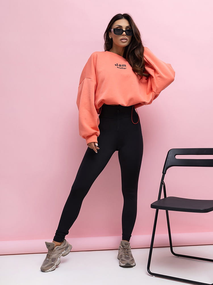 damski komplet pomarańczowa bluza oversize i czarne legginsy z wysokim stanem oraz zamkiem z przodu