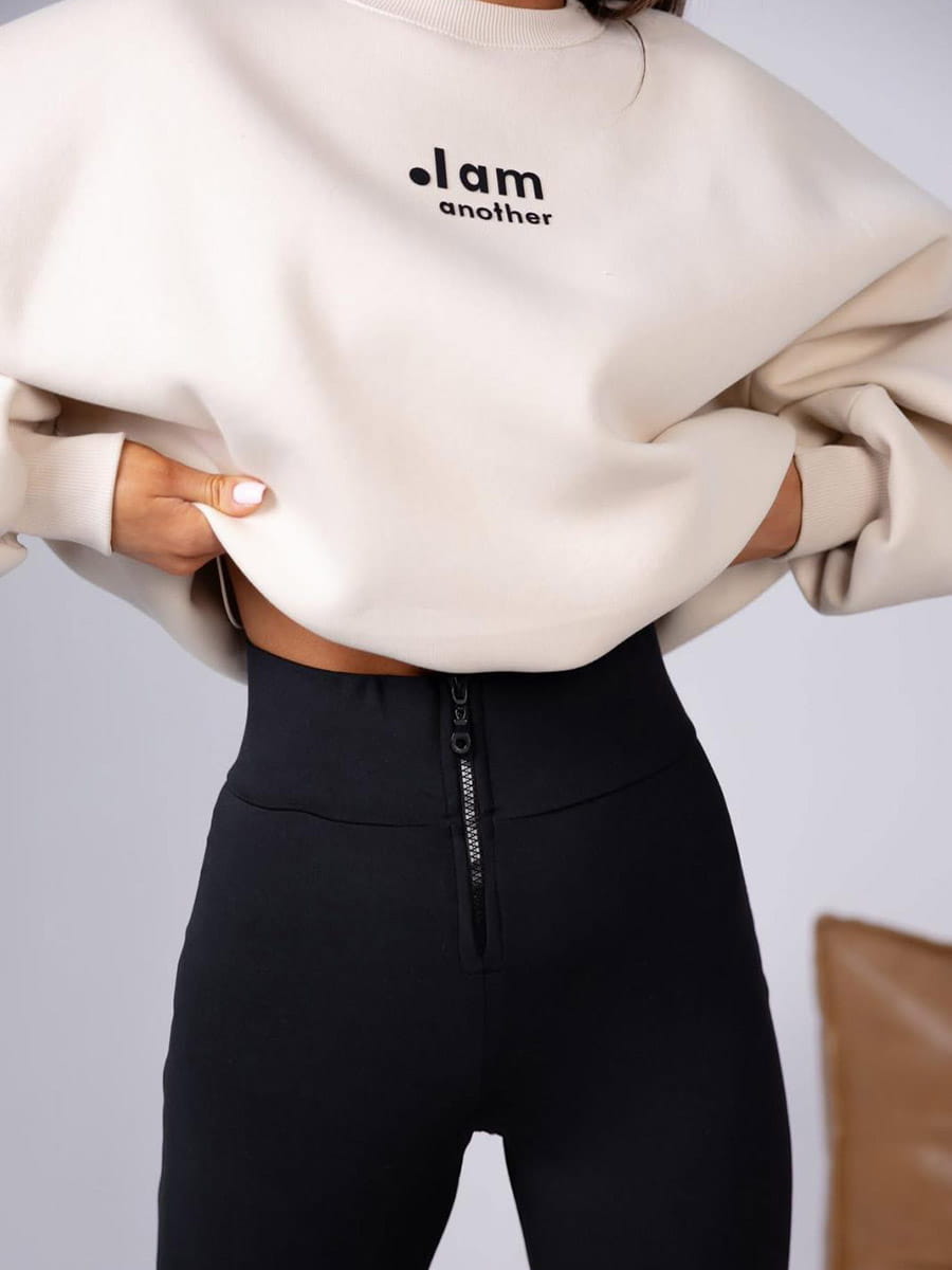 damski komplet beżowa bluza oversize i czarne legginsy z wysokim stanem oraz zamkiem z przodu