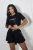Schwarzes Sommer-Set: Crop-Shirt mit Stickerei und ausgestellte Shorts w Rock-Optik